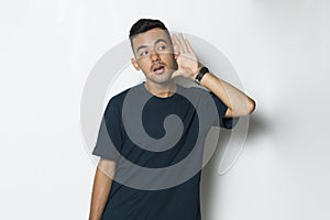 Young handsome man with hand over ear listening an hearing to gossip isolated on white background