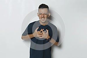 Young handsome man having heart attack isolated on white background