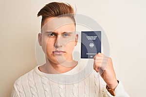 Young handsome man holding Germany German passport over isolated white background with a confident expression on smart face