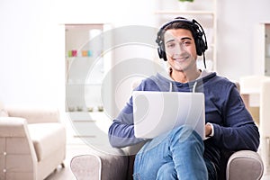 The young handsome man listening to music with headphones