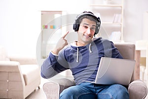 The young handsome man listening to music with headphones