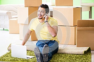 The young handsome man moving in to new house with boxes