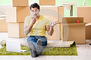 The young handsome man moving in to new house with boxes