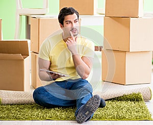 Young handsome man moving in to new house with boxes