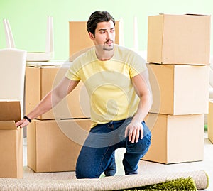 Young handsome man moving in to new house with boxes