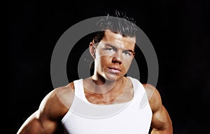 Young handsome man with muscles over dark