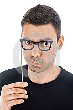 Young handsome man with paper glasses making faces