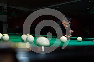 Young handsome man playing billiard game alone