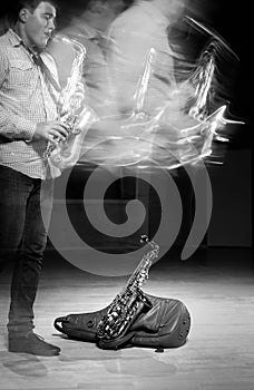 Young handsome man playing music on saxophone