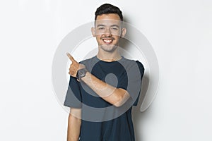 Young handsome man pointing finger on empty space isolated on white background