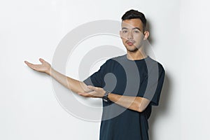 Young handsome man pointing finger on empty space isolated on white background