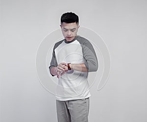 Young handsome man posing wearing raglan t-shirt with grey and white color isolated on background