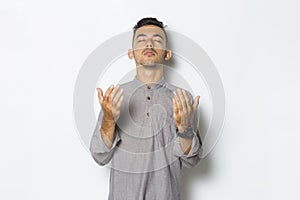 Young handsome man praying isolated on white background