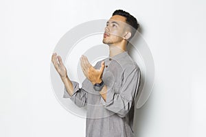 Young handsome man praying isolated on white background