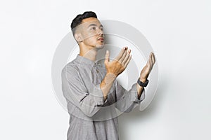 Young handsome man praying isolated on white background