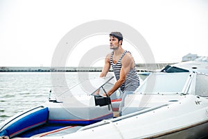 Young handsome man preparing boat to start a journey