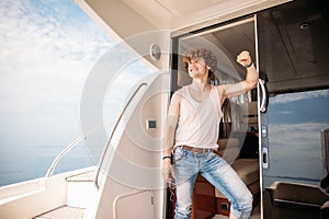 Young handsome man preparing boat to start a journey, standing on the boat