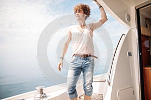 Young handsome man preparing boat to start a journey, standing on the boat