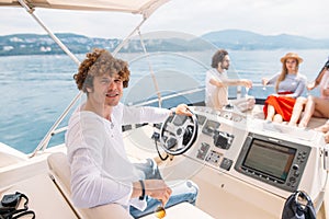 Young handsome man preparing boat to start a journey, standing on the boat