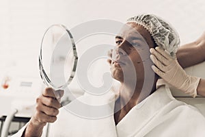 Young Handsome Man in Robe Loking into Mirror.