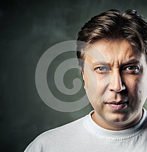 Young handsome man with serious expression on dark