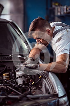 Young handsome man servicing vehicle