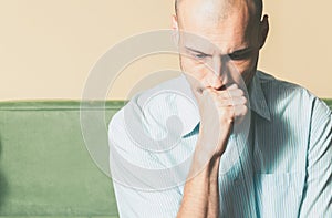 Young handsome man in the shirt with sad face expression feeling depressed and miserable while he thinking about life.