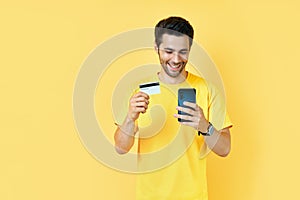 Young handsome man shopping online with credit card using smart phone