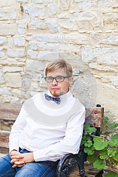 Young handsome man with short hair wearing a bow tie and posing in the city streets.