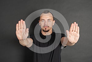 Young handsome man showing stop gesture
