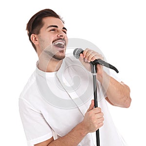 Young handsome man singing in microphone on white