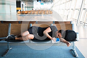 Young handsome man sleeping at the airport while waiting for delayed flights