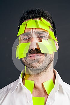 Young handsome man with sticky notes on his face