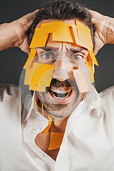 Young handsome man with sticky notes on his face