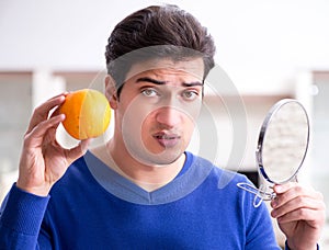 Young handsome man taking care of face skin