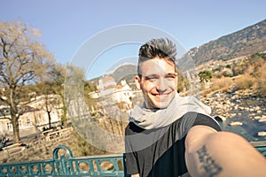 Young handsome man taking selfie by Passer river at Meran city