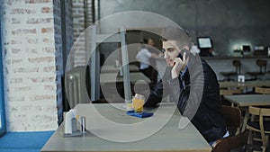 Young handsome man talking on the smartphone in the cafe 4K