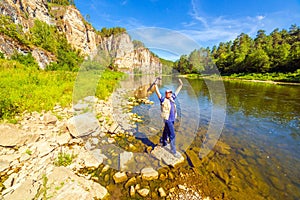 A young handsome man tourist on the bank of the Ai River against the backdrop of the Aisky cliffs photo