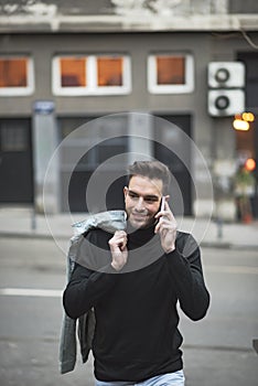 Young handsome man using his cell phone, enjoying a day on the street