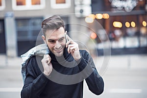 Young handsome man using his cell phone, enjoying a day on the street