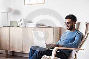 Young handsome man using laptop computer at home. Student men resting  in his room.