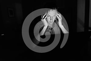 Young handsome man using laptop in the dark living room