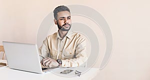 Young handsome man using laptop at home, Businessman or student working online on computer indoors