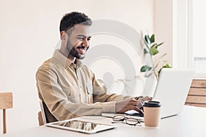 Young handsome man using laptop at home, Businessman or student working online on computer indoors