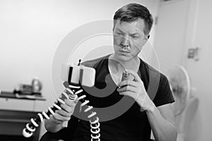 Young handsome man vlogging with asthma inhaler at home