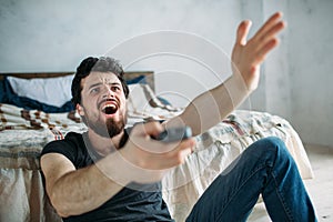 Young handsome man watching TV on a floor at home