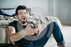 Young handsome man watching TV on a floor at home