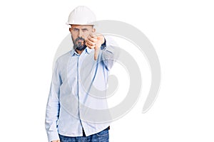 Young handsome man wearing architect hardhat looking unhappy and angry showing rejection and negative with thumbs down gesture