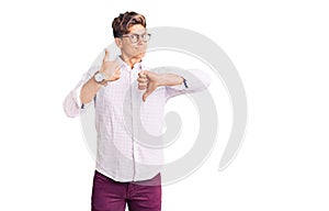 Young handsome man wearing business clothes and glasses doing thumbs up and down, disagreement and agreement expression