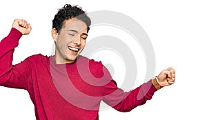 Young handsome man wearing casual clothes dancing happy and cheerful, smiling moving casual and confident listening to music